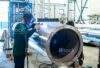 Welder welding stainless steel big pipe at industry workshop