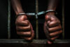 Prisoner holding metal cage in jail, no freedom concept