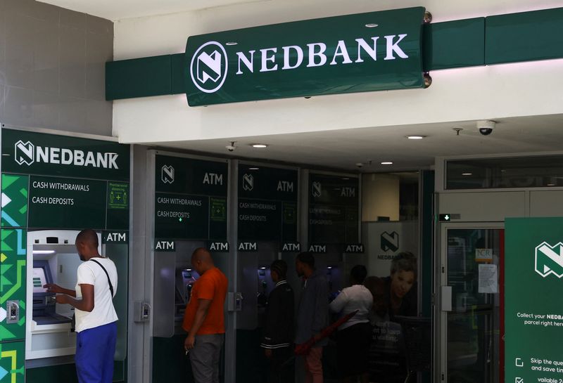 Customers using a Nedbank automated teller machine (ATM) at Trade Route Mall in Lenasia, South Africa