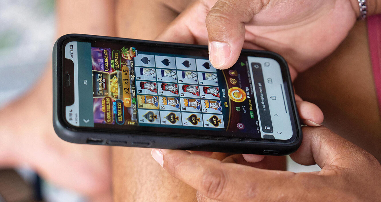A young person using a smartphone for online sports betting and gambling in South Africa