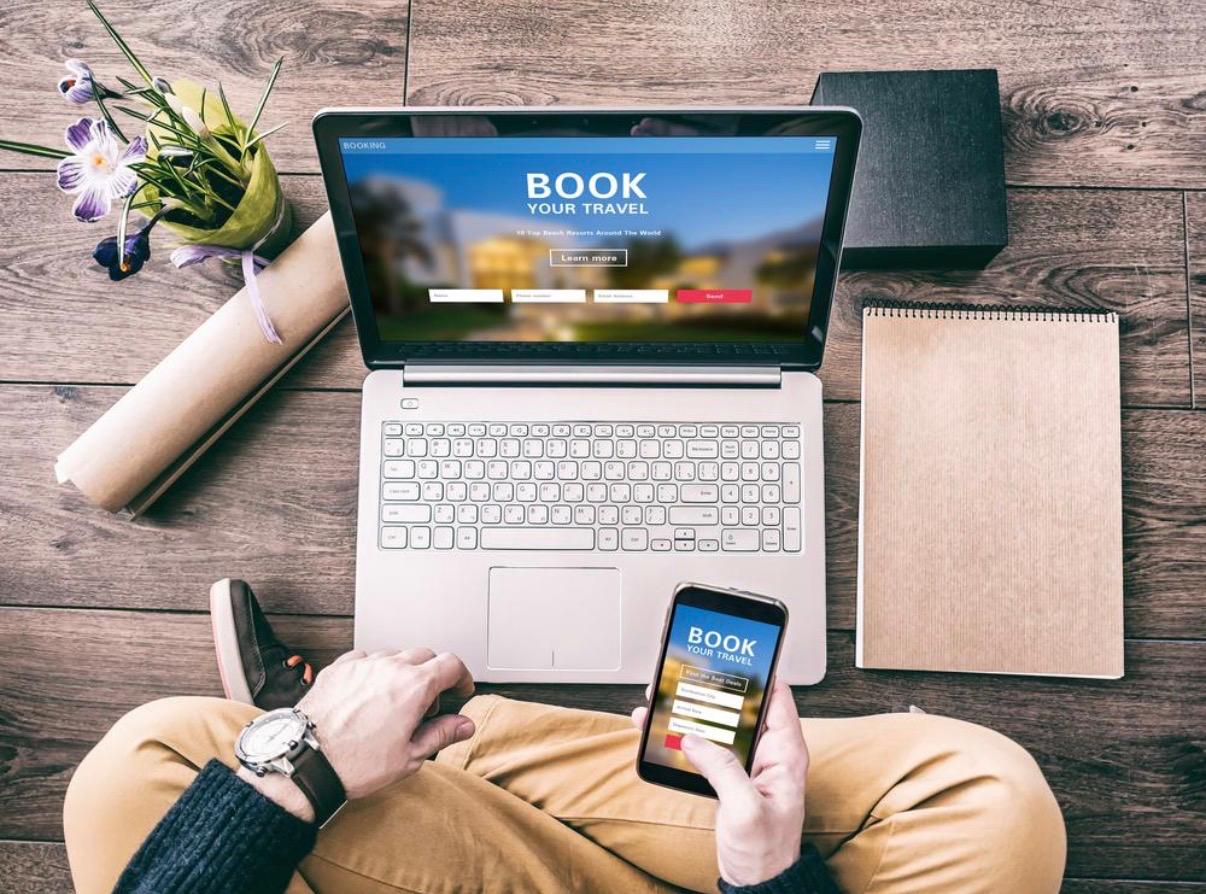 Travel consultant assisting a client with planning a holiday using a laptop